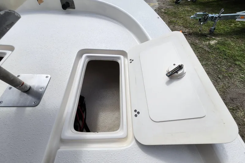 Slide: The Image of 2017 Carolina Skiff 1765 DLX boat storage compartment with open hatch on deck. - 15