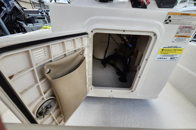 Slide: The Image of Open storage compartment on a 2017 Carolina Skiff 1765 DLX boat, showing interior details. - 19