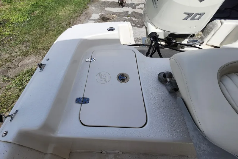 Slide: The Image of 2017 Carolina Skiff 1765 DLX boat deck with storage compartment and outboard motor. - 25