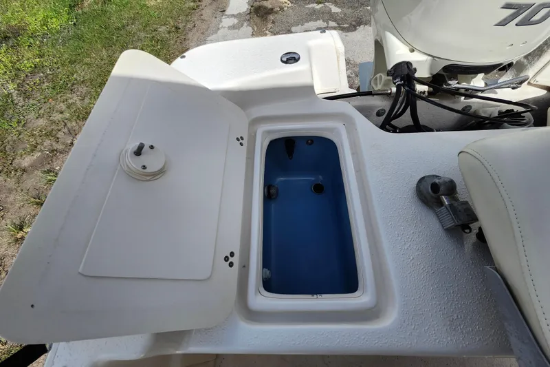 Slide: The Image of 2017 Carolina Skiff 1765 DLX boat with open storage compartment and visible motor. - 26