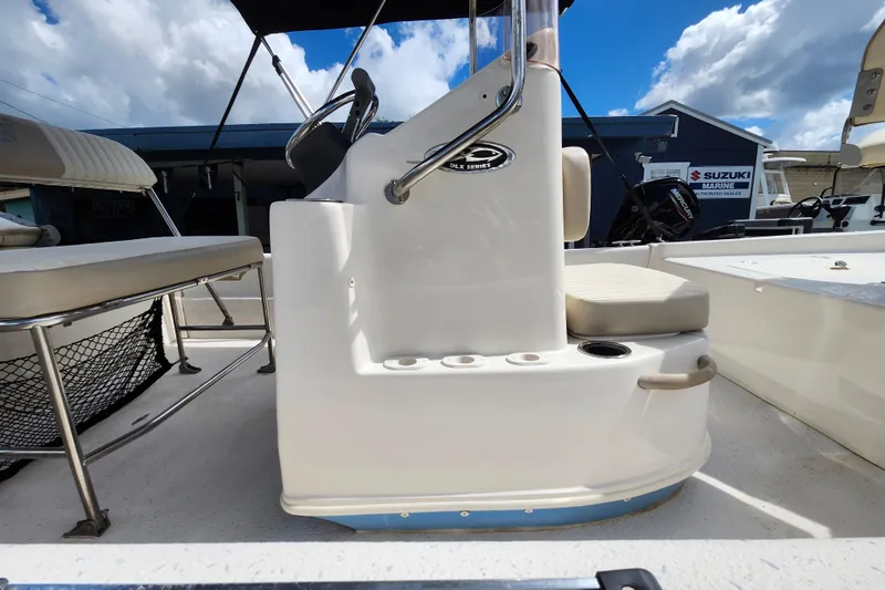 Slide: The Image of 2017 Carolina Skiff 1765 DLX boat interior with console and seating under blue sky. - 29