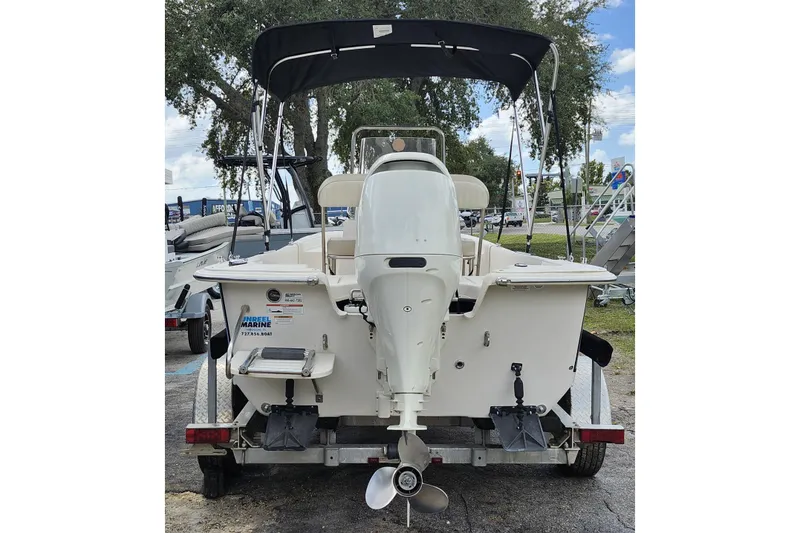 Slide: The Image of 2017 Carolina Skiff 1765 DLX boat, rear view with motor and canopy, on trailer. - 3