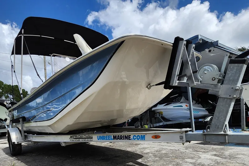Slide: The Image of 2017 Carolina Skiff 1765 DLX boat on trailer under blue sky. - 32