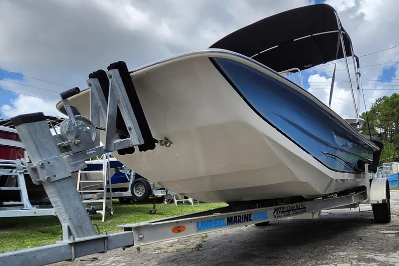 Slide: The Image of 2017 Carolina Skiff 1765 DLX boat on trailer, under cloudy sky. - 33