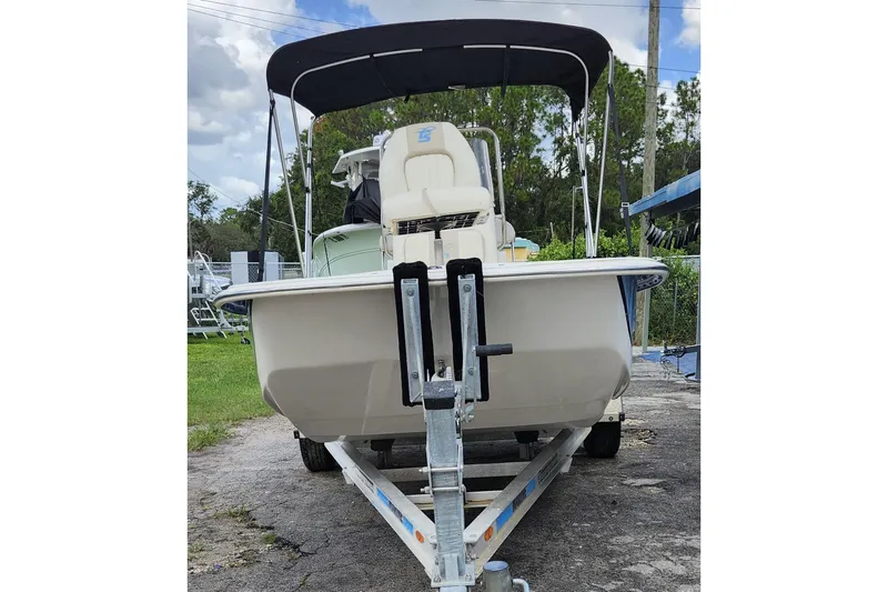 Slide: The Image of 2017 Carolina Skiff 1765 DLX boat on trailer with canopy, parked outdoors. - 34