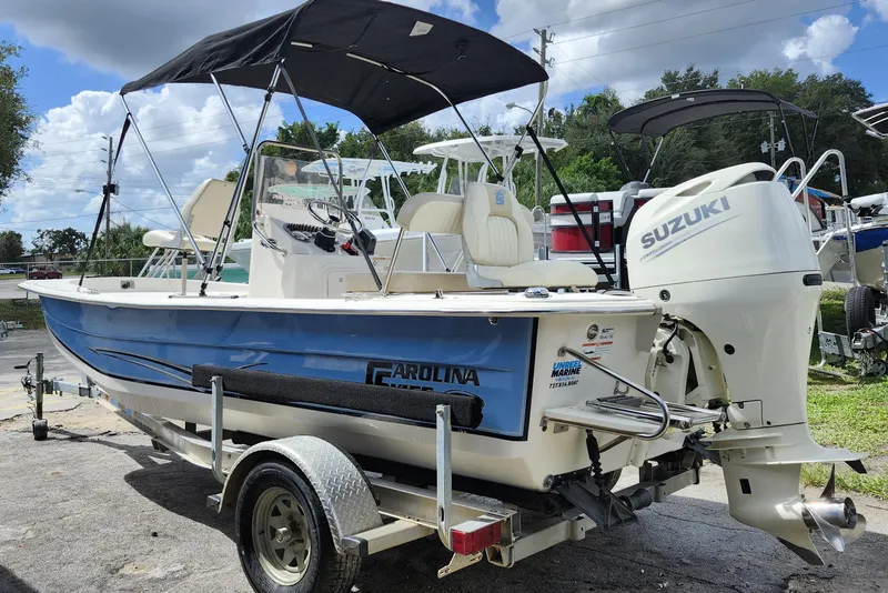 Slide: The Image of 2017 Carolina Skiff 1765 DLX boat with Suzuki outboard motor on trailer. - 4