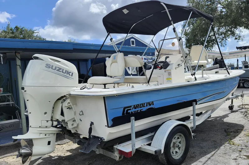 Slide: The Image of 2017 Carolina Skiff 1765 DLX boat with Suzuki outboard motor on trailer. - 5