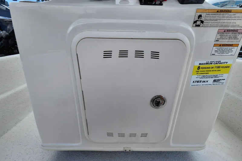 Slide: The Image of 2017 Carolina Skiff 1765 DLX boat console with capacity and safety warnings. - 9