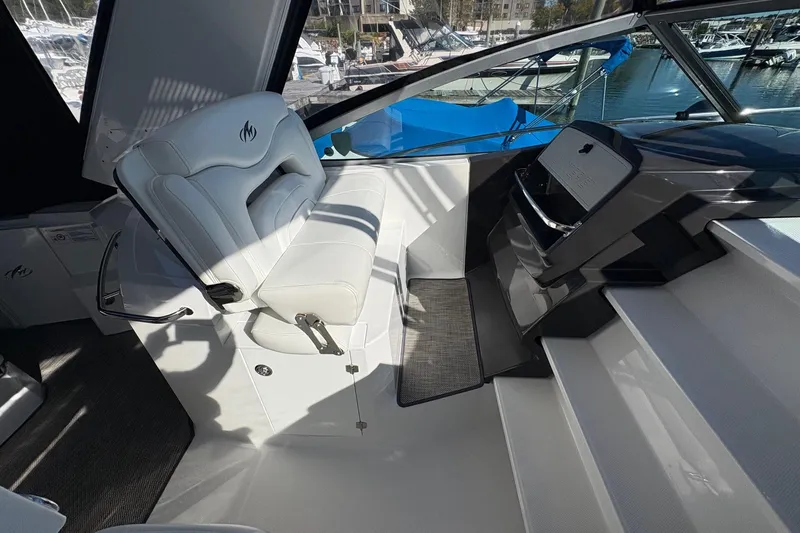 Slide: The Image of 2018 Monterey 335 Sport Yacht cockpit with white seating and modern dashboard. - 11