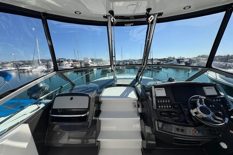 Slide: The Image of 2018 Monterey 335 Sport Yacht cockpit with marina view, featuring modern controls and steering wheel. - 13