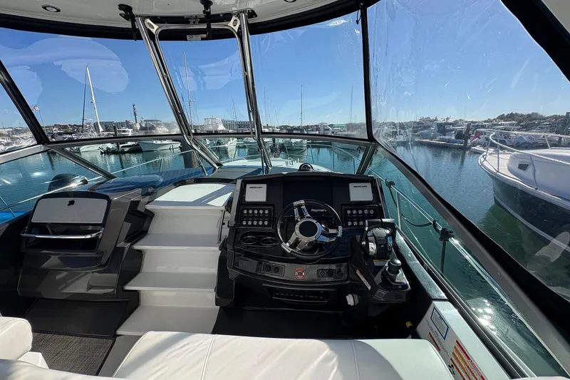 Slide: The Image of 2018 Monterey 335 Sport Yacht helm with marina view, showcasing modern controls and navigation. - 8