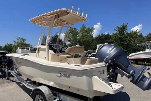 Slide: The Image of 2026 Scout 195 Sportfish boat with Yamaha outboard engine on trailer, under clear blue sky. - 3