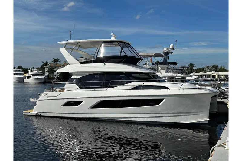 Slide: The Image of Aquila 44 Yacht 2021 docked in a marina under a clear blue sky. - 0