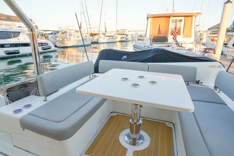 Slide: The Image of Aquila 44 Yacht 2021, elegant seating area with table, docked in marina. - 30