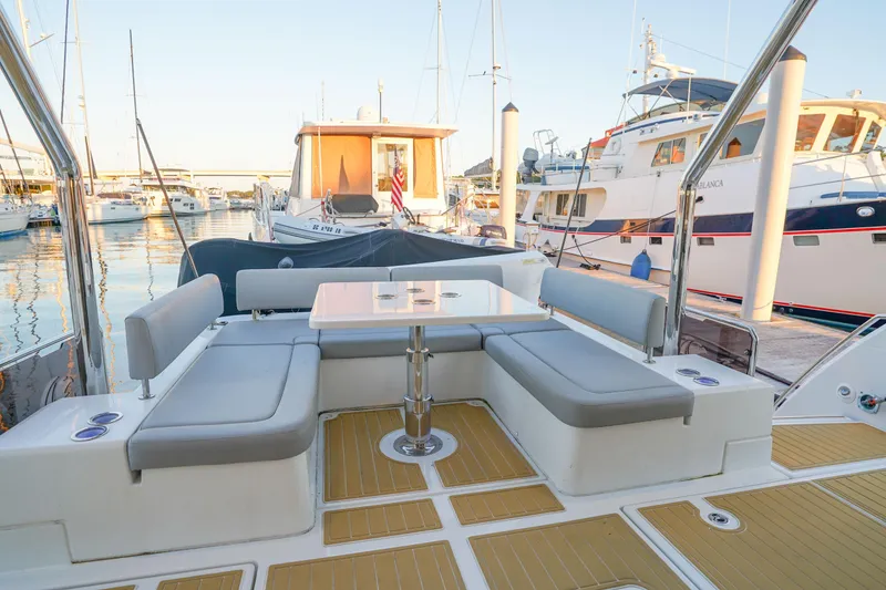 Slide: The Image of Aquila 44 Yacht 2021 with elegant seating area in a marina setting. - 31