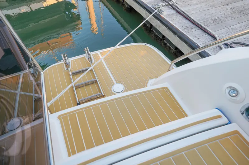 Slide: The Image of Aquila 44 Yacht 2021 stern view with swim platform and ladder at dock. - 32