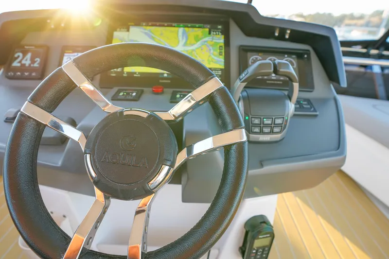 Slide: The Image of Steering wheel and controls of 2021 Aquila 44 Yacht with sunlight. - 45