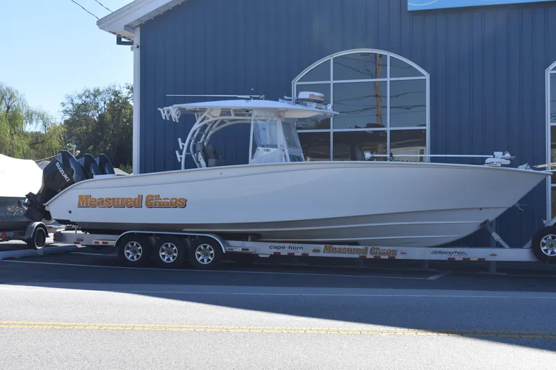 The Image of 2021 Cape Horn 36 XS boat on trailer outside blue building. - 0