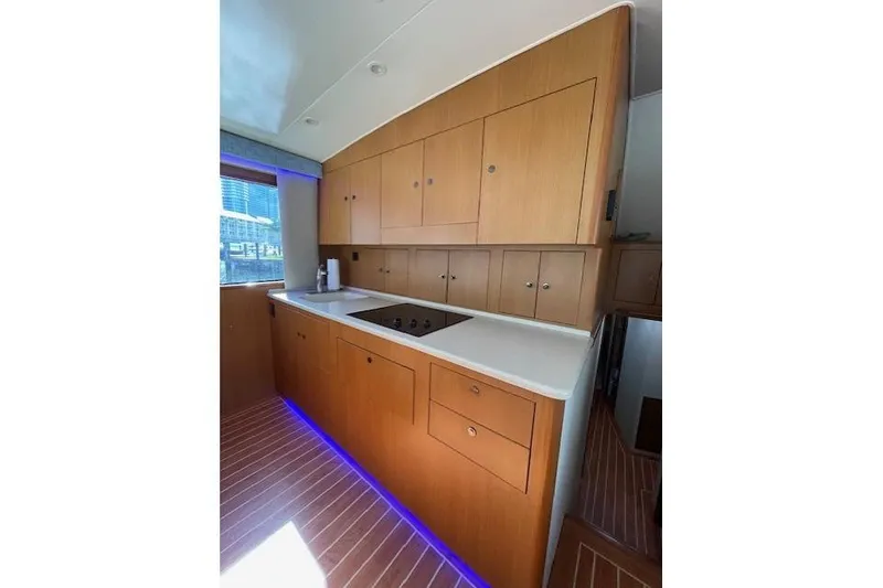Slide: The Image of 2003 Post Flybridge Convertible yacht kitchen with wooden cabinets and modern appliances. - 16