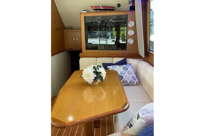 Slide: The Image of Interior of 2003 Post Flybridge Convertible yacht with cozy seating and elegant wooden table. - 18