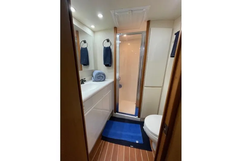 Slide: The Image of Bathroom interior of 2003 Post Flybridge Convertible yacht with modern fixtures and blue towels. - 25