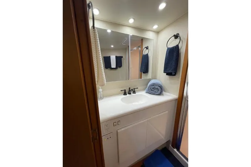 Slide: The Image of 2003 Post Flybridge Convertible cabin with wooden cabinetry and cozy bedding. - 26