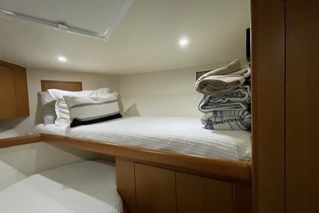 Slide: The Image of 2003 Post Flybridge Convertible cabin with wooden cabinetry and bunk beds. - 29