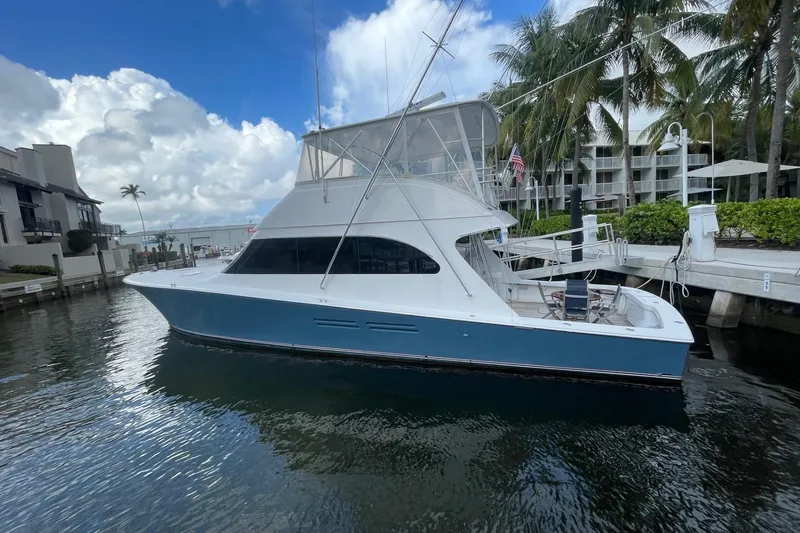 Slide: The Image of 2003 Post Flybridge Convertible yacht docked in a marina, surrounded by palm trees. - 3