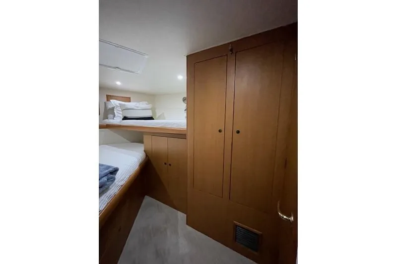 Slide: The Image of 2003 Post Flybridge Convertible cabin interior with wooden cabinetry and cozy bedding. - 30