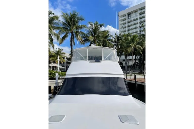 Slide: The Image of 2003 Post Flybridge Convertible yacht docked near palm trees and a modern building. - 41