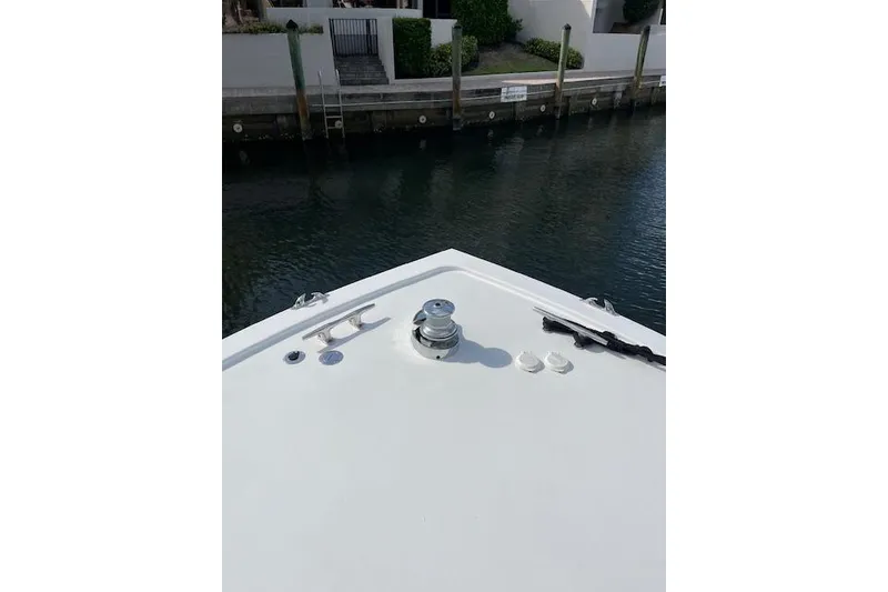 Slide: The Image of Outdoor seating on 2003 Post Flybridge Convertible yacht, featuring wooden deck and round table. - 43