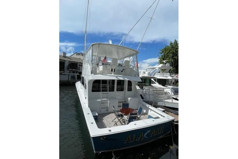 Slide: The Image of 2003 Post Flybridge Convertible yacht docked, featuring spacious deck and seating area. - 45