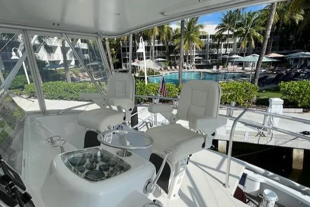 Slide: The Image of 2003 Post Flybridge Convertible boat interior with cushioned seating and marina view. - 48