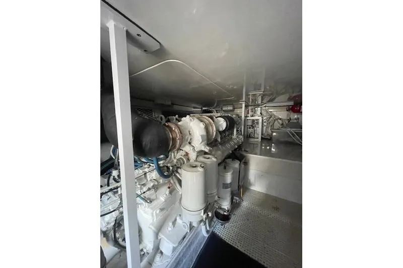 Slide: The Image of Engine room of a 2003 Post Flybridge Convertible boat, featuring dual engines and mechanical components. - 51