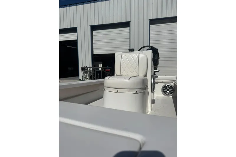 Slide: The Image of 2023 Lagoon 14 boat interior with white cushioned seat and steering wheel. - 2