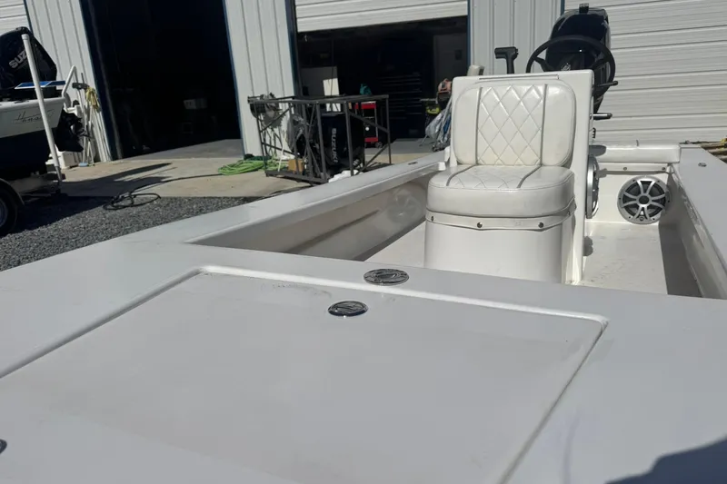 Slide: The Image of 2023 Lagoon 14 boat interior with white seating and steering wheel in a garage setting. - 3