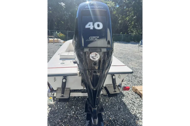 Slide: The Image of 2023 Lagoon 14 boat with Mercury 40 CT outboard motor, parked on gravel. - 9