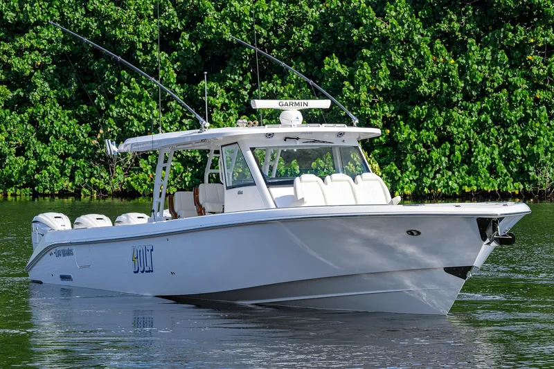 Slide: The Image of 2024 Everglades 455 Center Console boat on water, surrounded by lush greenery. - 1
