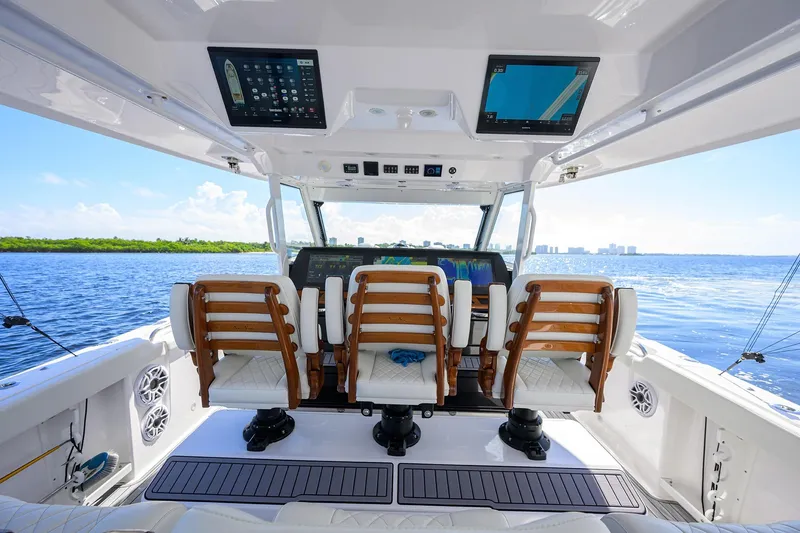 Slide: The Image of 2024 Everglades 455 Center Console boat interior with advanced navigation screens and luxurious seating. - 10
