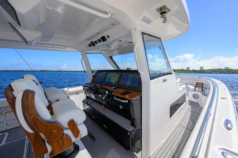 Slide: The Image of 2024 Everglades 455 Center Console boat interior with luxurious seating and advanced navigation system. - 13
