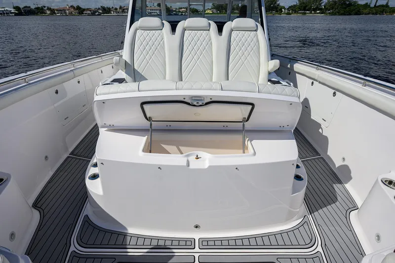 Slide: The Image of 2024 Everglades 455 Center Console boat interior with white seating and storage compartment. - 22