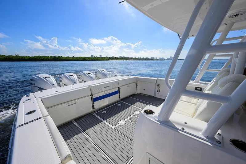 Slide: The Image of 2024 Everglades 455 Center Console boat on water, featuring spacious deck and multiple engines. - 27