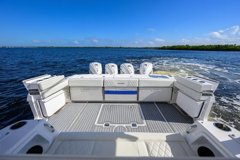 Slide: The Image of 2024 Everglades 455 Center Console boat on open water, showcasing spacious deck and engines. - 31