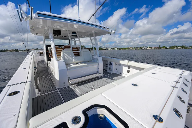 Slide: The Image of 2024 Everglades 455 Center Console boat on water, featuring spacious deck and seating. - 35