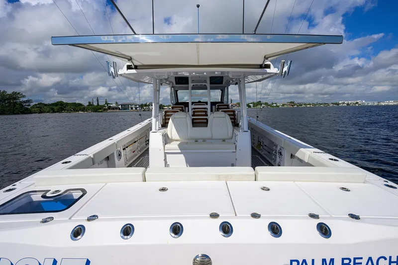 Slide: The Image of 2024 Everglades 455 Center Console boat on calm water under cloudy sky. - 36