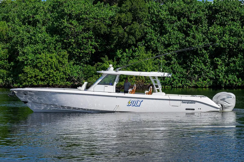 Slide: The Image of 2024 Everglades 455 Center Console boat on calm water, surrounded by lush greenery. - 4