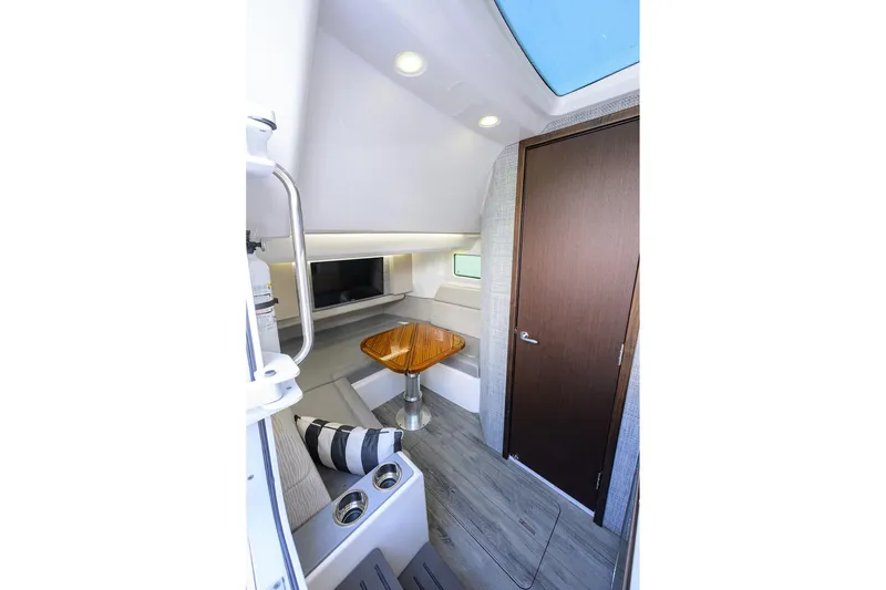 Slide: The Image of 2024 Everglades 455 Center Console cabin interior with seating and wooden table. - 40