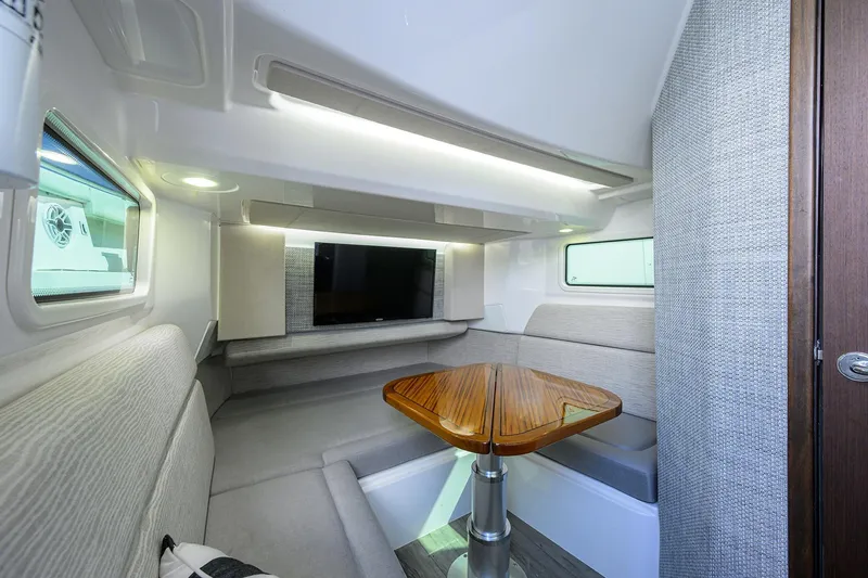 Slide: The Image of 2024 Everglades 455 Center Console cabin with modern seating and wooden table. - 41