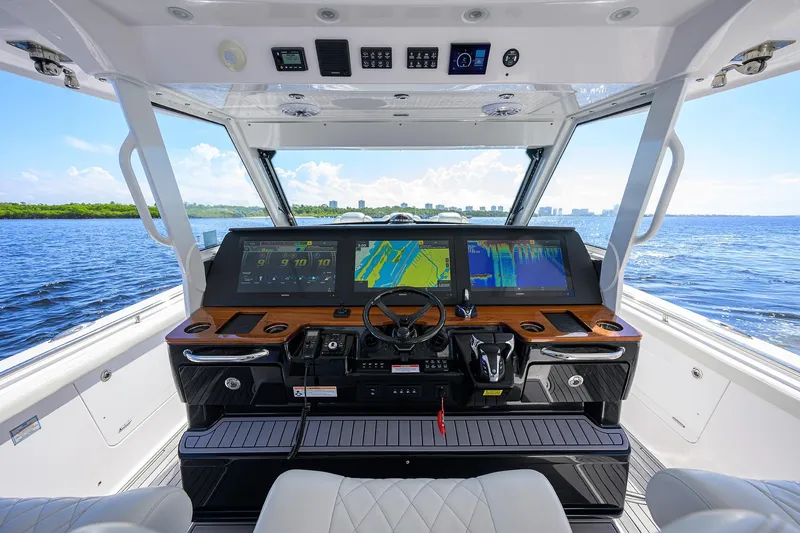 Slide: The Image of 2024 Everglades 455 Center Console helm with advanced navigation displays on open water. - 9