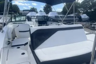 Slide: The Image of 2023 Sea Ray SPX 210 Outboard boat with sleek seating and canopy, docked outdoors. - 6